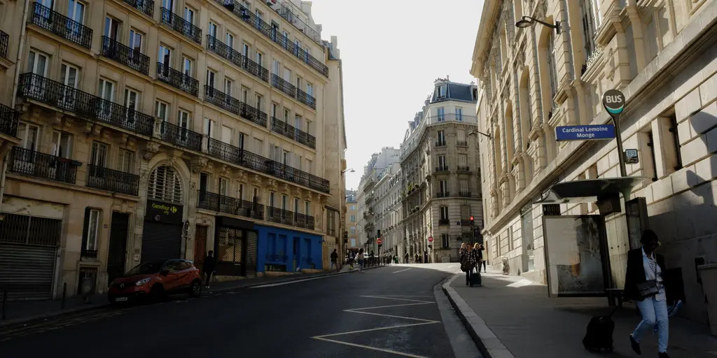 Rue ensoleillée, immeubles anciens et piétons